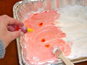 Adding yellow food coloring drops to make orange.